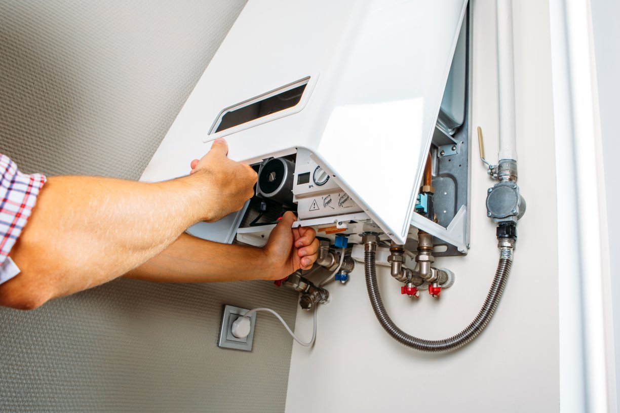 plumber attaches trying fix problem with residential heating equipment repair gas boiler